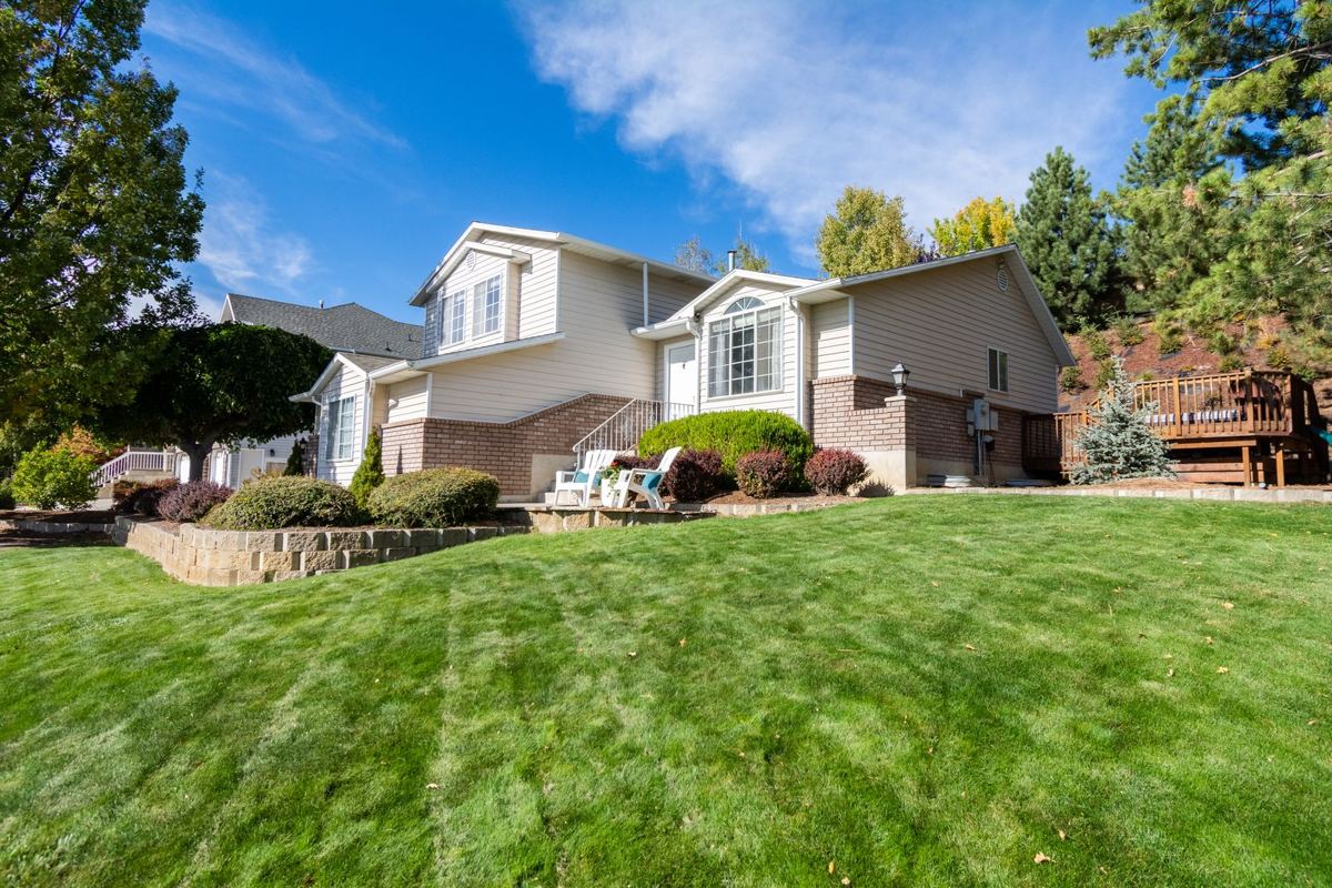 Freshly striped lawn, planting beds and a stone retaining wall in front of a suburban home