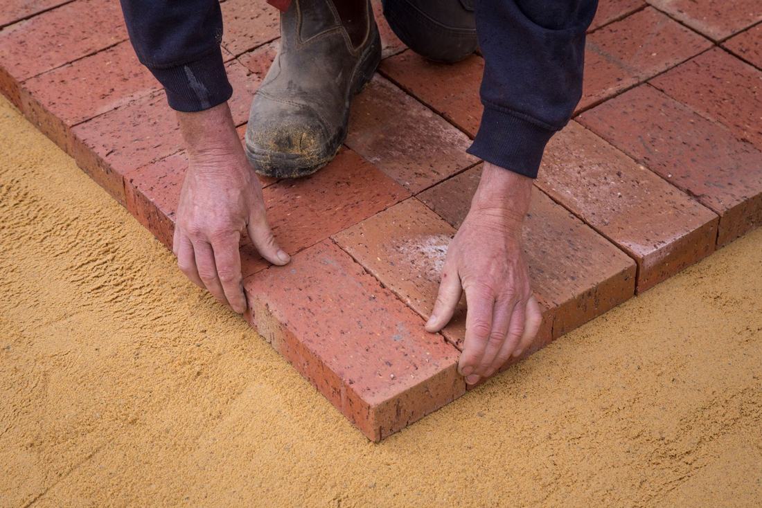 Brick pavers being set on a sand base