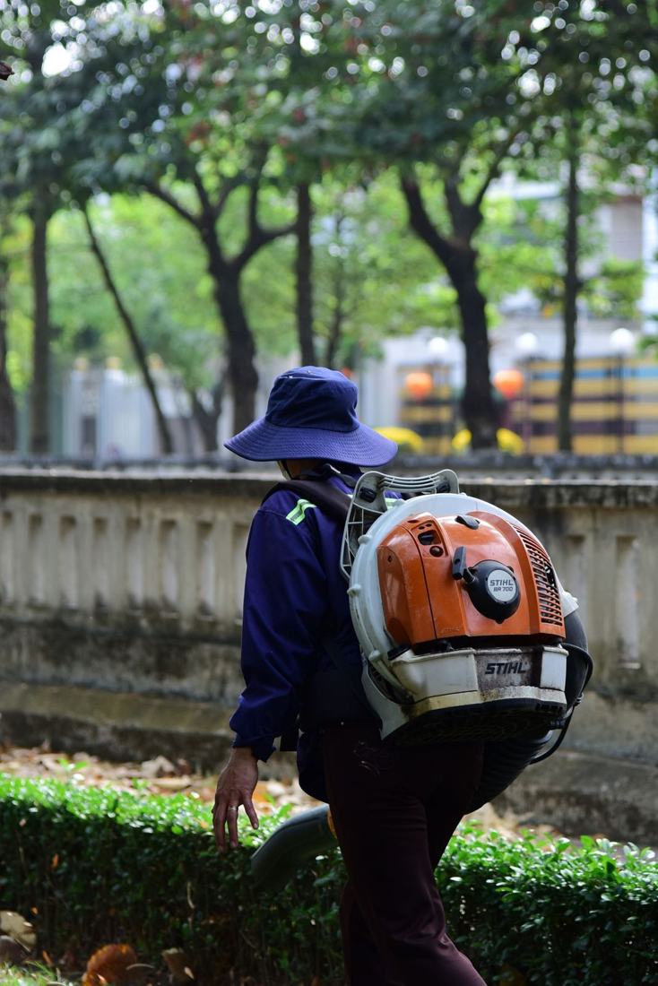 Worker clearing leaves with a backpack blower